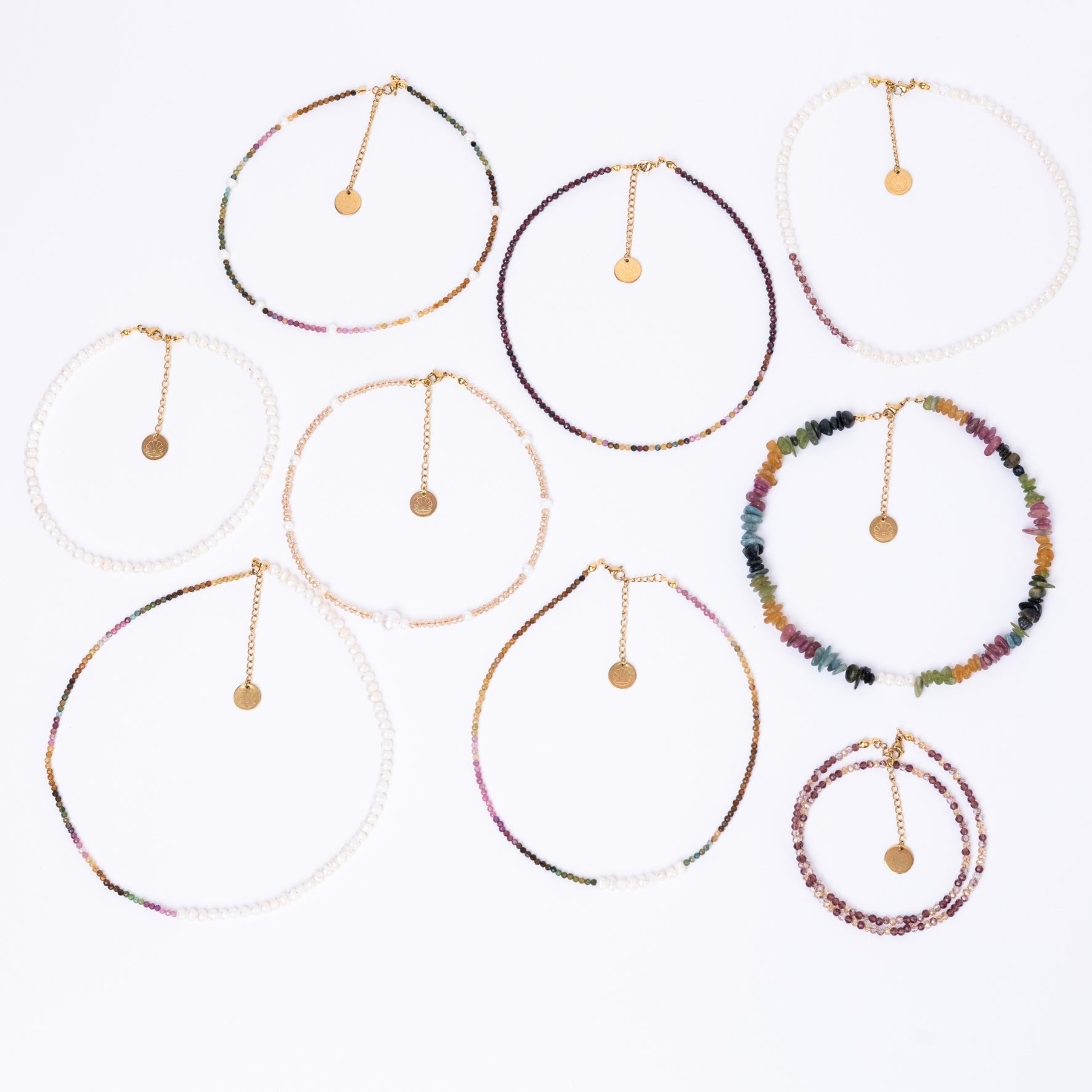 Handmade necklaces crafted with the Nacre Creative Mother Earth DIY Jewelry Kit, featuring freshwater pearls, tourmaline gemstones, crystal beads, and 18k gold-plated clasps in a variety of designs.