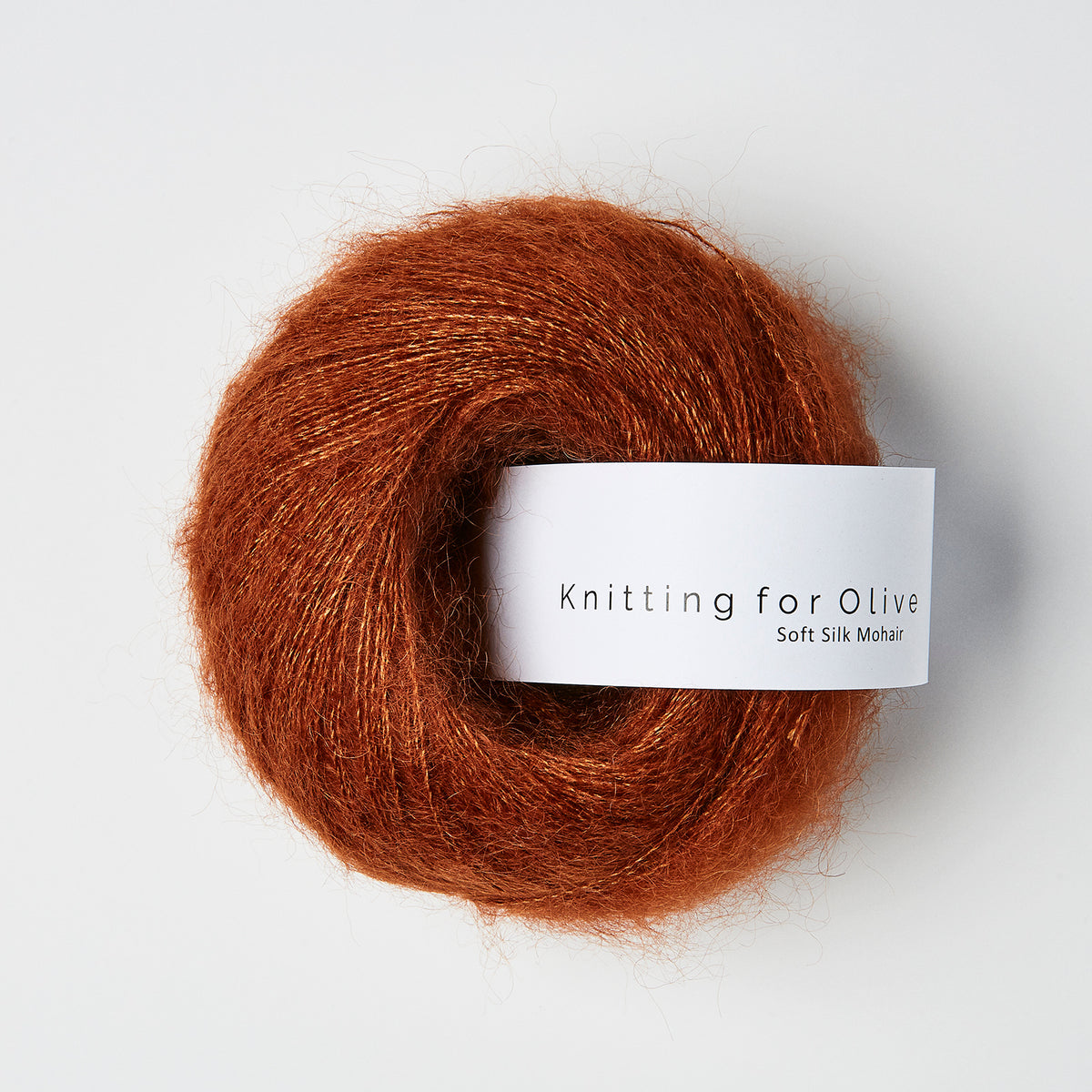 Knitting for Olive Soft Silk Mohair yarn in Rust. Ball of brown yarn with a 'Knitting for Olive' label on a white background.